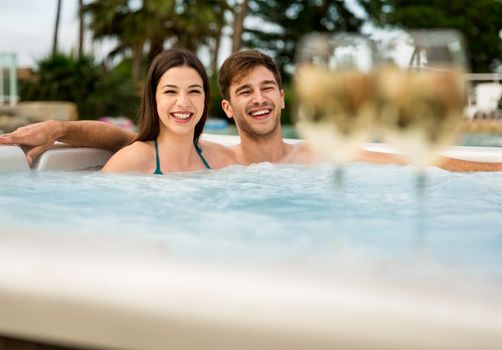 Young couple inside a jacuzzi and tasting wine
