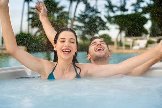 Young couple in a luxury hotel inside a jacuzzi in a rainy day 