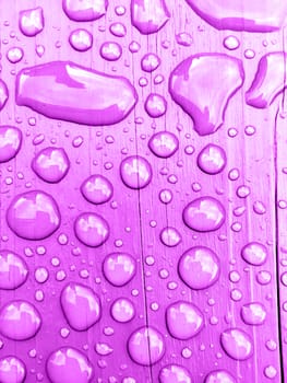 rain drops on on purple wooden bench