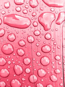 rain drops on on pink wooden bench