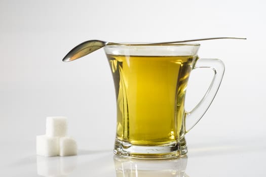 Tea in a glass on a white background. Green or fruit tea. Glass of white glass