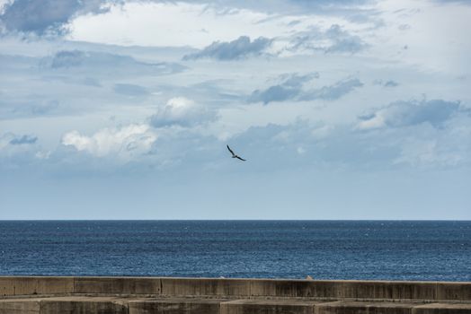 horizon with the clouds and blue sea view from castelsardo harbour on the italian island of sardinia or sardegna
