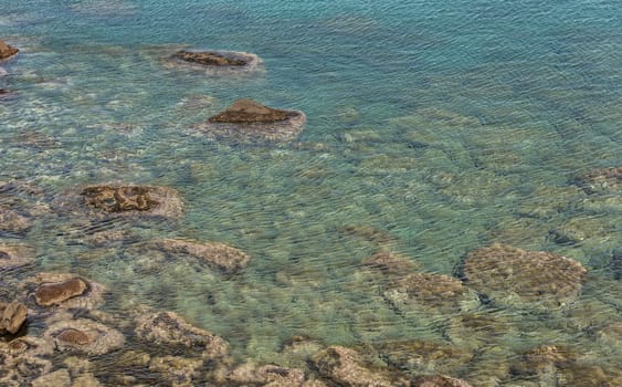 clear water in the sea round sardinia island with rocks and stones