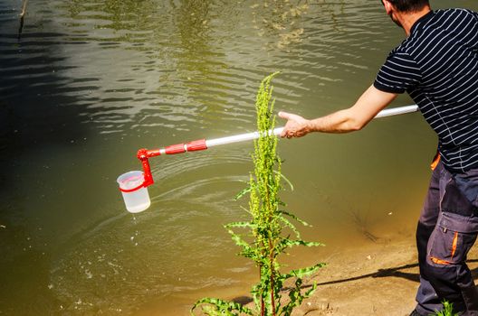 Take samples of water for laboratory testing. The concept - analysis of water purity, environment, ecology