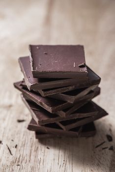 Stack of Chocolate Bars on Wooden Surface. Vertical Orientation.