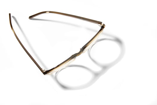 Studio shot of pair of eyeglasses on white background with shadow.