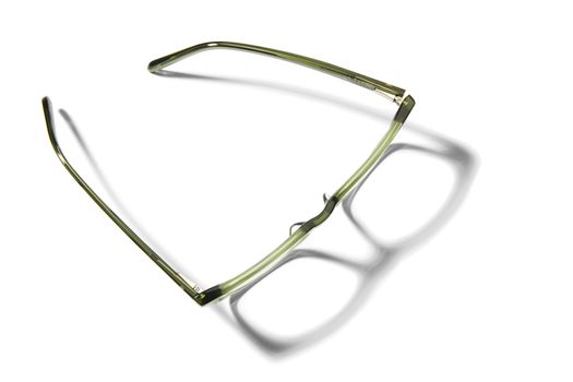 Studio shot of pair of green eyeglasses on white background with shadow.