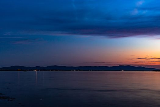 The sun went over the horizon of the Amur river in the city of Khabarovsk, forming magnificent colors in the sky. Beautiful colors in the sky, which are reflected in the water.