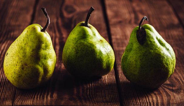 Three Green Pear on Wooden Background. Close Up.
