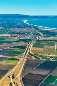 Pacific coast of California with farmland around freeway 101 and Monterey Bay visible in the up right corner. The picture was taken in the early July.