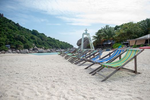 The deck chair is on the island with mountains in the background.