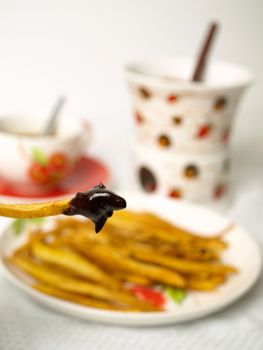 Homemade potatoes chips with chocolate fondue on white background