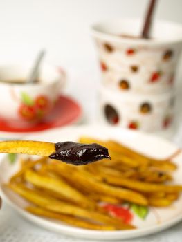 Homemade potatoes chips with chocolate fondue on white background