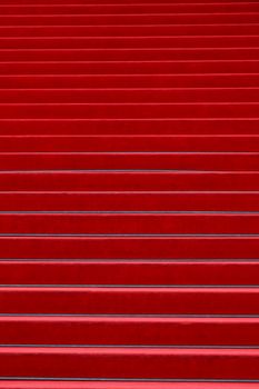 Close up red carpet covered stairs perspective ascending, low angle view