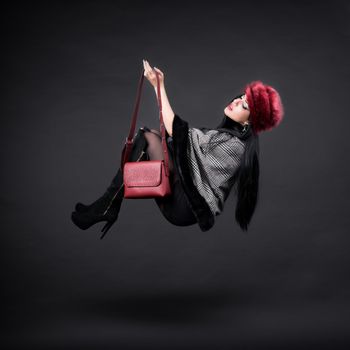 Creative picture of a beautiful flying girl in fashion winter outfit