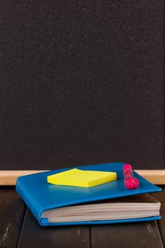 Stationery: pens, pen holder, diary on a black background