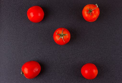 red tomatoes on black background. top view