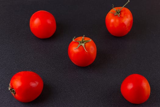 red tomatoes on black background. top view