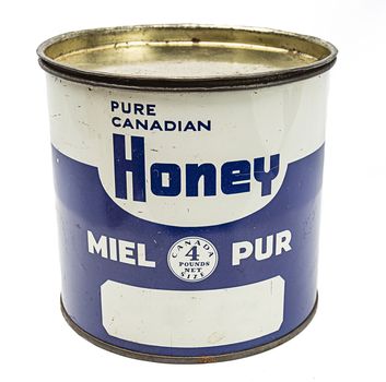 Vintage metal box of honey against white background