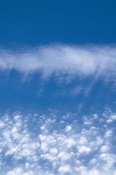 Streaky and puffy Cirrocumulus Clouds against blue sky. Portrait orientation.