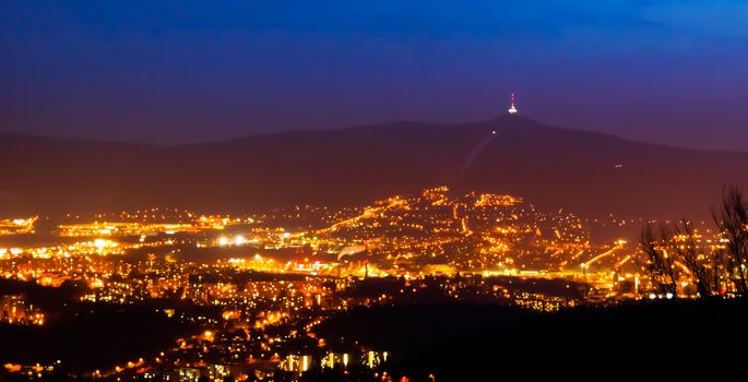 Evening view of illuminated Liberec city and Jested Mountain. Night scene.