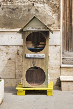 free library on a pallet in a street in alghereo on the street for everyone to use for borrowing books,