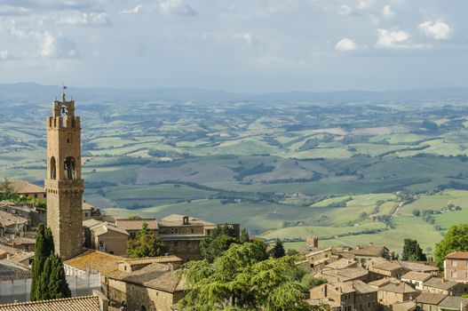 Rooftops of Montalcino and scenic view of typical Tuscany landscape in Val D'Orcia: hills, meadows and green fields. Tuscany, Italy, Europe