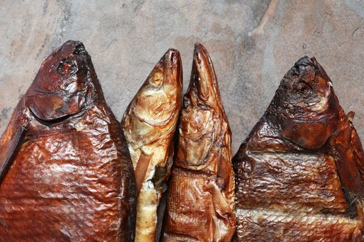 Closeup of few freshness smoked fishes on stone background