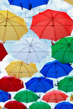 Lot of diversity color umbrellas as background against blue sky