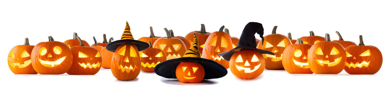 Big collection of Jack O Lantern Halloween pumpkins with various different designs and witches hat in a row isolated on white background