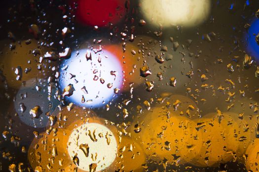 Water drops on window with color background