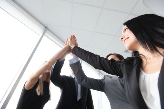 Happy smiling business people giving high five in the office