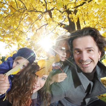 Parents and children having fun in yellow autumn park