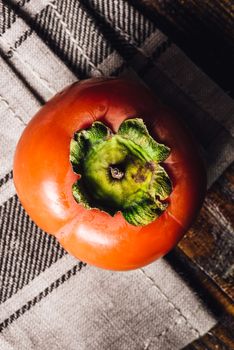 One Persimmon on Cloth. View from Above.