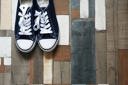 Pair of keds on color wooden background with free space