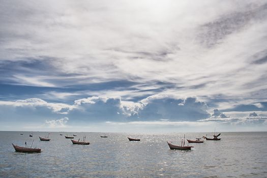 Fisherman's boat among calm sea and beautiful cloudy sky
