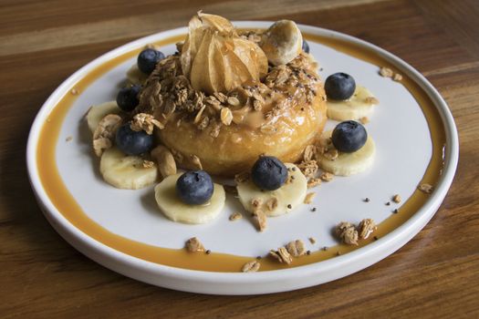 Cake with Peanut Butter on top with Granola Banana and Berry Close Up on Wooden Table 