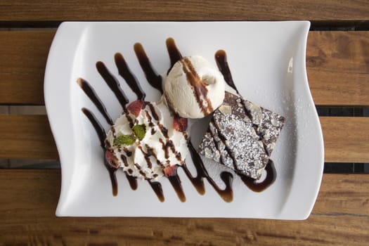 Dark Chocolate Brownie serve with Vanilla ice cream and Whip cream Flat Lay