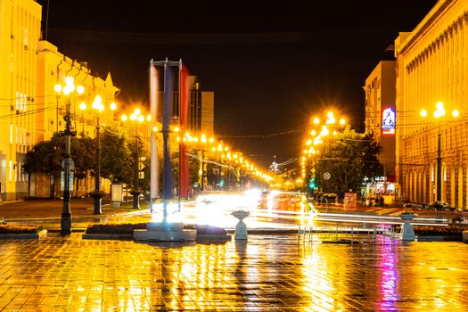 Night city landscape. The main square of the city of Khabarovsk in the light of lanterns, which are reflected in puddles after the rain just passed.