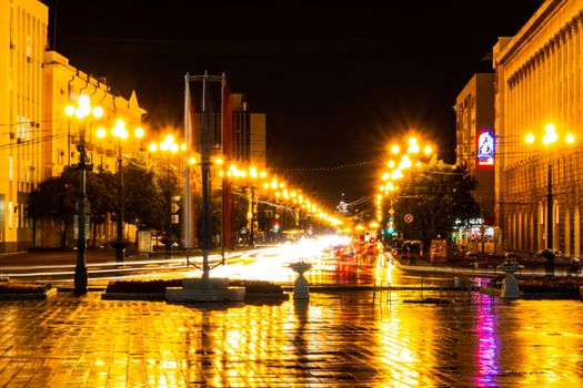 Night city landscape. The main square of the city of Khabarovsk in the light of lanterns, which are reflected in puddles after the rain just passed.