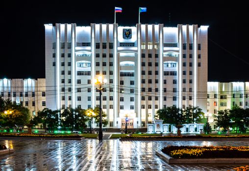 Night city landscape. The main square of the city of Khabarovsk in the light of lanterns, which are reflected in puddles after the rain just passed.