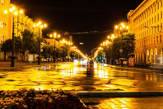 Night city landscape. The main square of the city of Khabarovsk in the light of lanterns, which are reflected in puddles after the rain just passed.