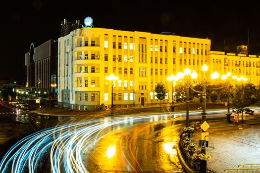 Night city landscape. The main square of the city of Khabarovsk in the light of lanterns, which are reflected in puddles after the rain just passed.