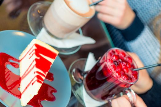 Close-up of delicious strawberry cheesecake and hot drinks in a cafe