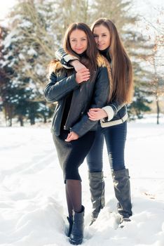 Hugging the best girlfriends in the winter in the snow
