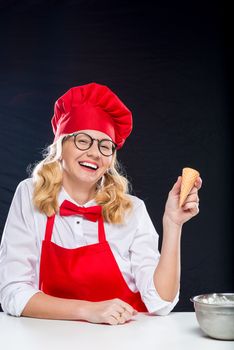 Cheerful cook with ice cream in a red suit on a black background