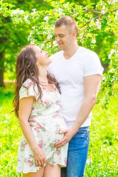 happy young married couple in anticipation of a child, portrait in the park