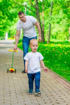father and son on a walk in a summer park spend a weekend together