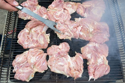 Raw pork chops on grill. Smoke rising from heated grill