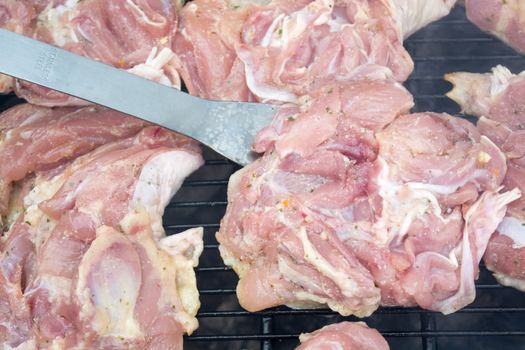 Raw pork chops on grill. Smoke rising from heated grill